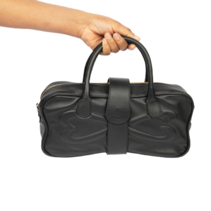 Medium black leather handbag in hand.