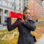 Model holding small leather red bag.